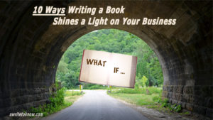A road with a tunnel, and a large, shining white book showing the words “What If?” leading the way into the green valley beyond, with overlying text saying, “10 Ways Writing a Book Shines a Light on Your Business.”