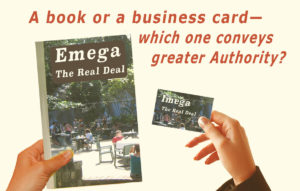 On the left we see a woman’s hand holding a book, and on the right a hand holding a business card. The words ask, “Book of Business Card? Which one conveys greater authority?”